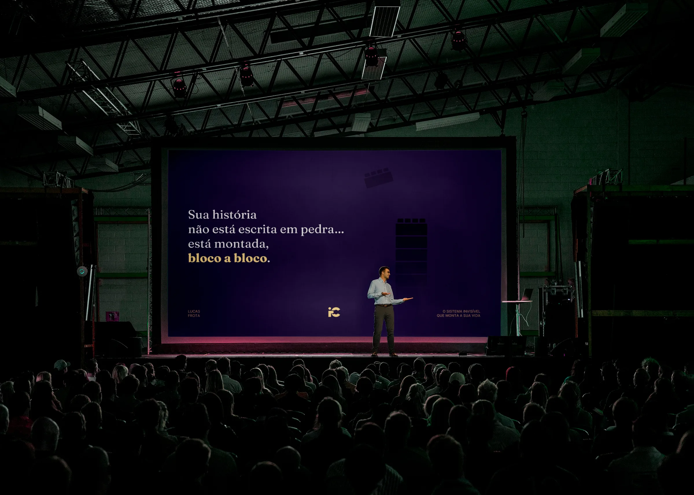 Lucas Frota no palco diante da plateia, com a frase de abertura projetada ao fundo